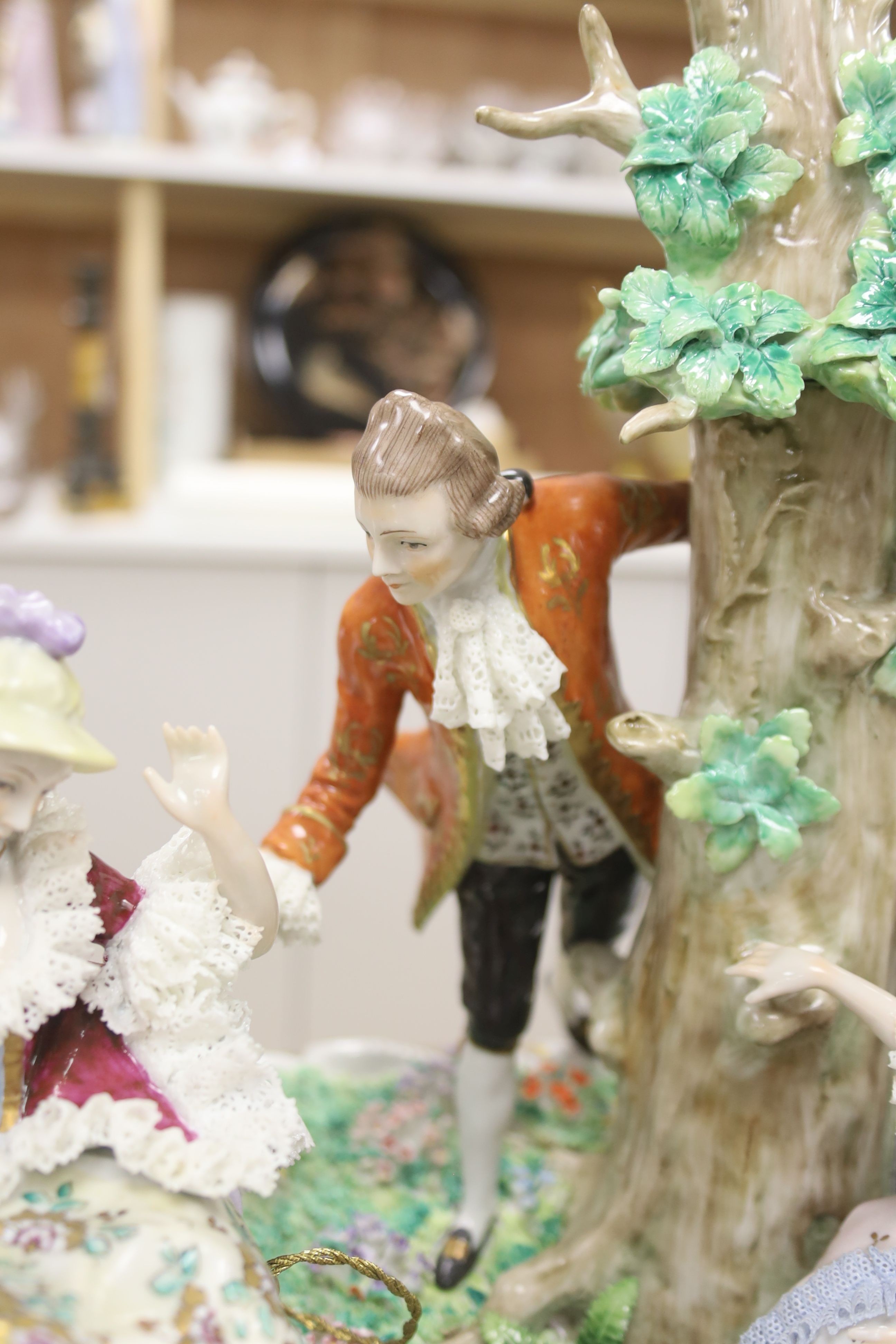 A large and impressive Sitzendorf porcelain figural group, the central figure seated on a swing, height 44cm